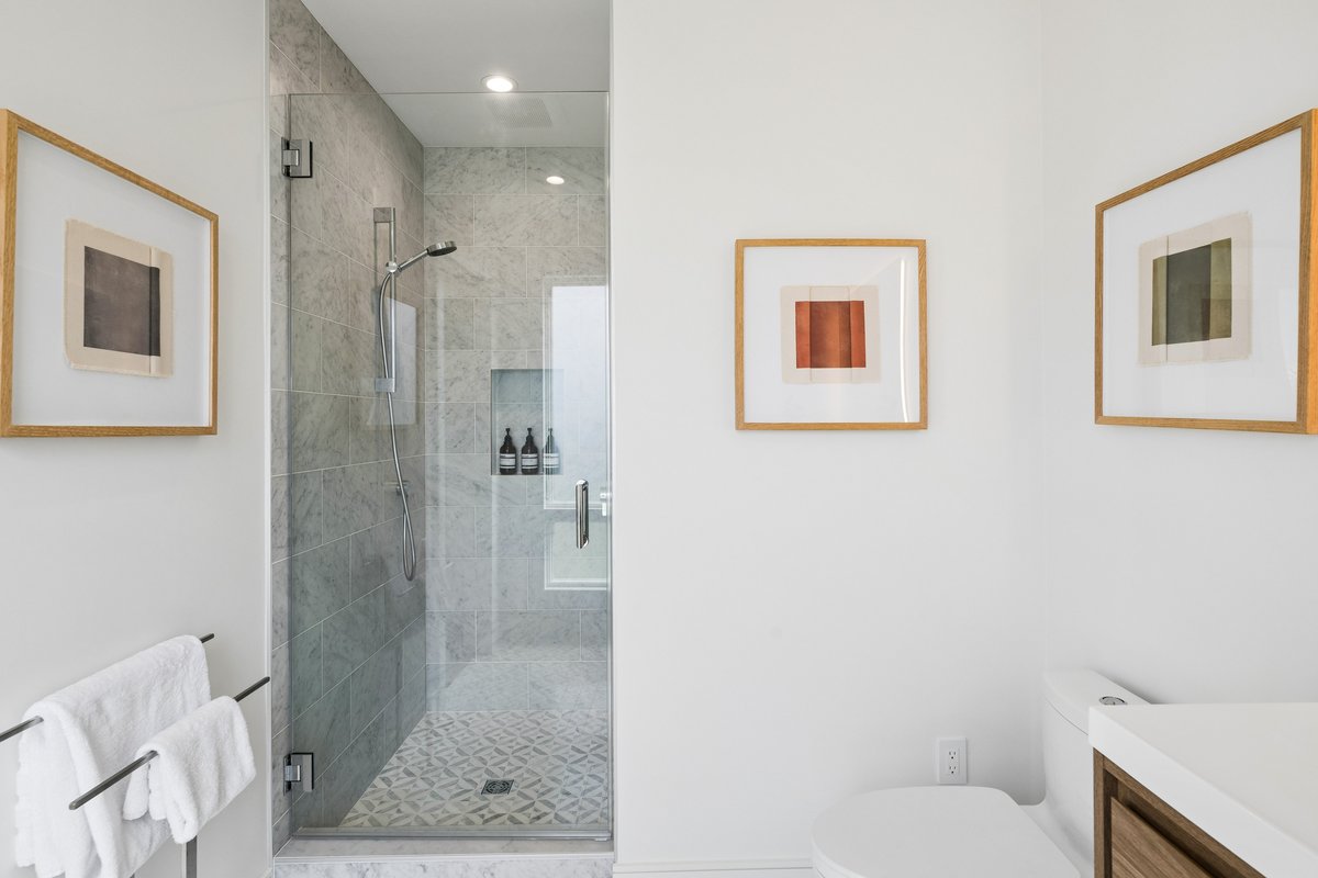 Ensuite marble bath for west bedroom; includes window, stall shower