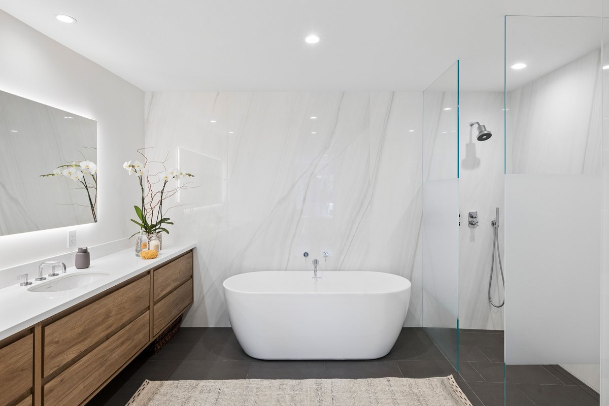 Primary suite's spa style bath featuring dual sinks, soaking tub and walk in shower